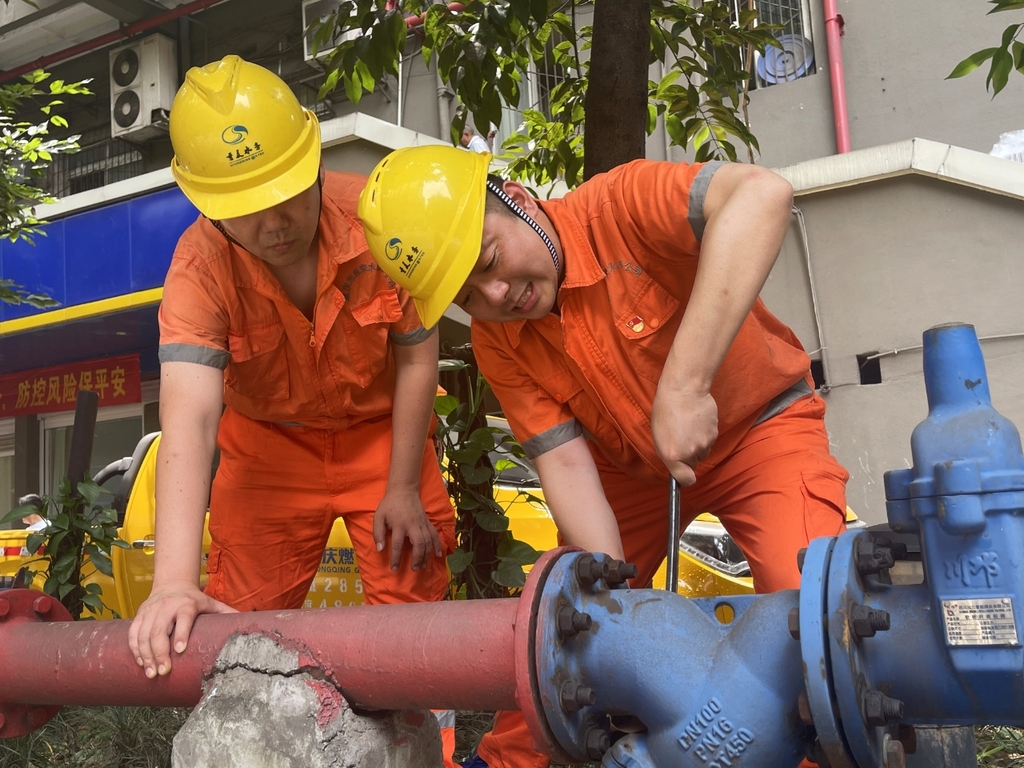 重庆水务集团所属市自来水公司沙坪坝营业管网所工作人员正在维修漏水管道。虽然烈日炎炎,但哪里有影响供水的问题,他们的身影就会出现在哪里。重庆市城市管理局供图