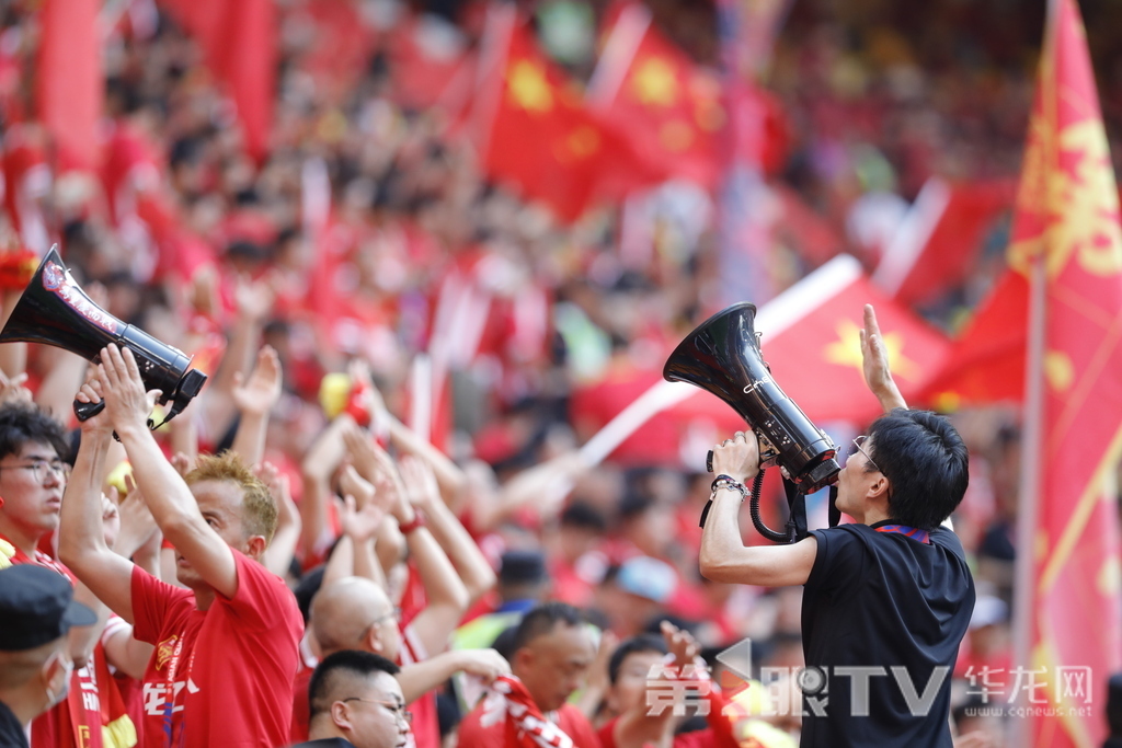 重庆龙兴足球场看台,球迷高举国旗、手持扩音器呐喊,点燃红色助威浪潮。第1眼TV-华龙网记者 石涛 摄
