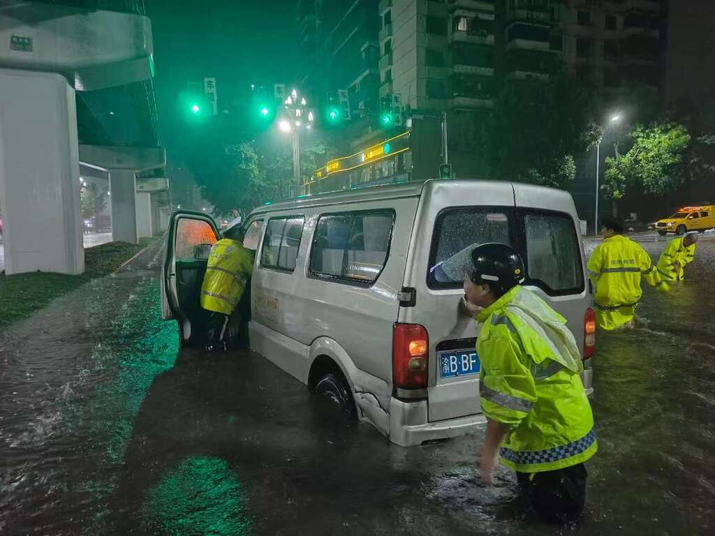 民警深夜在谢家湾正街积水路面推车脱困。 警方供图