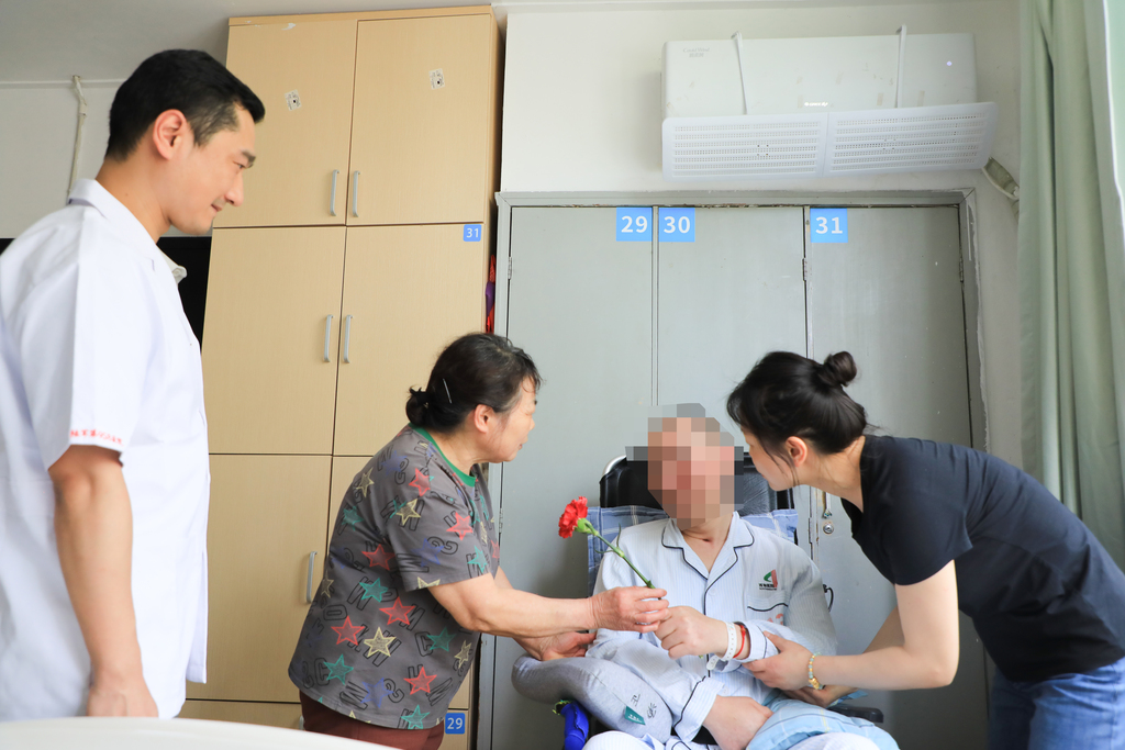 汤先生给母亲送上康乃馨。 西南医院江北院区供图