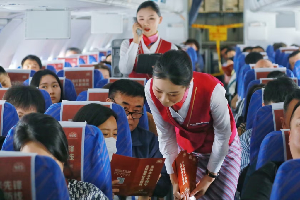 乘务组向旅客发放国家安全知识手册。重庆航空供图