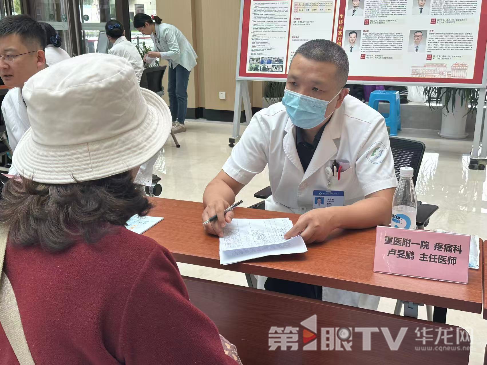 重医附一院疼痛科副主任、主任医师卢旻鹏对参加义诊的患者进行问诊。 第1眼TV-华龙网记者 唐雨 摄