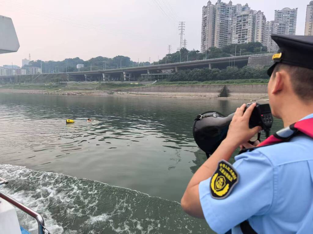 执法队员提醒游泳者远离航道。受访者供图