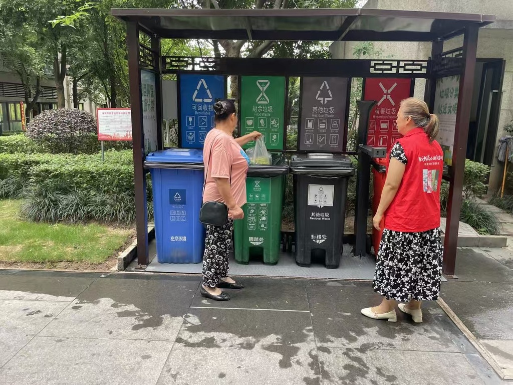 志愿者在指导居民投放生活垃圾。受访者供图