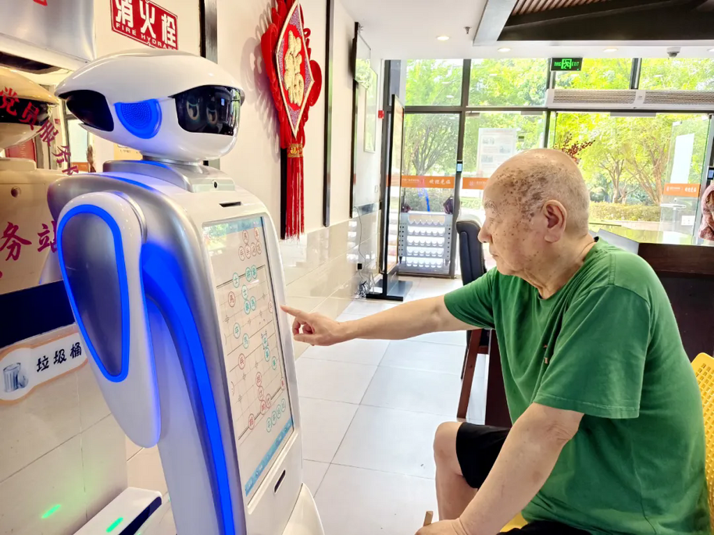 老人与情感陪护机器人下象棋。市民政局供图