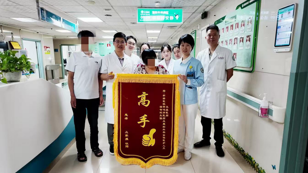 出院那天，傅奶奶一家将写着“高手”的锦旗送到了新桥医院整形外科医护团队手中。 新桥医院供图