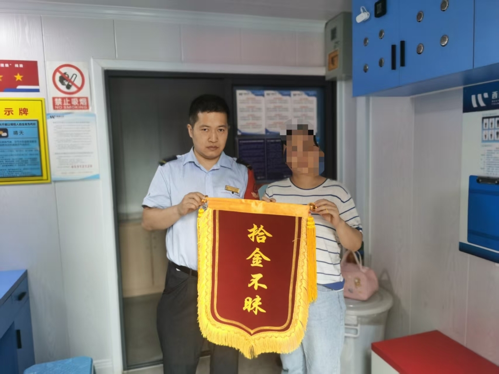 欧晓强(左)收到失主家人送来的锦旗。受访者供图