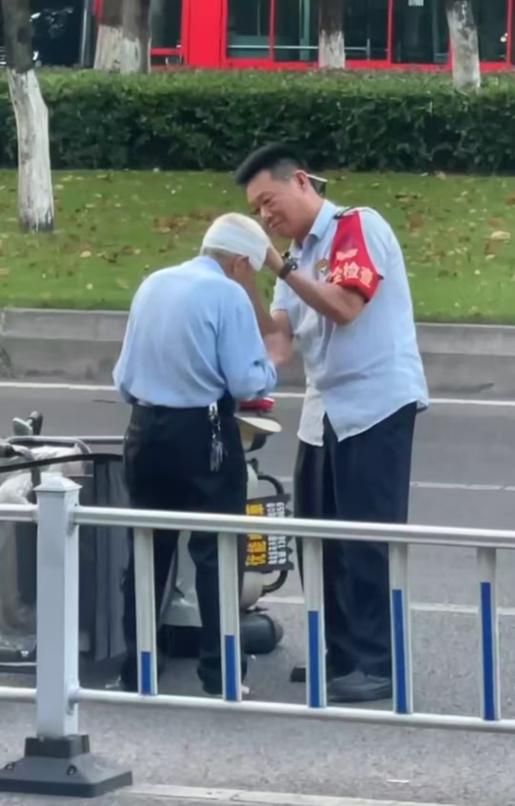 公交司机黄鸿军(右)帮老人包扎。视频截图