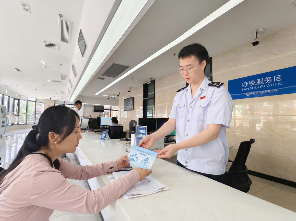 潼南区税务人员为企业财务人员发放“成渝纳税信用修复提示卡”，引导其及时更正涉税失信行为。重庆市税务局供图png