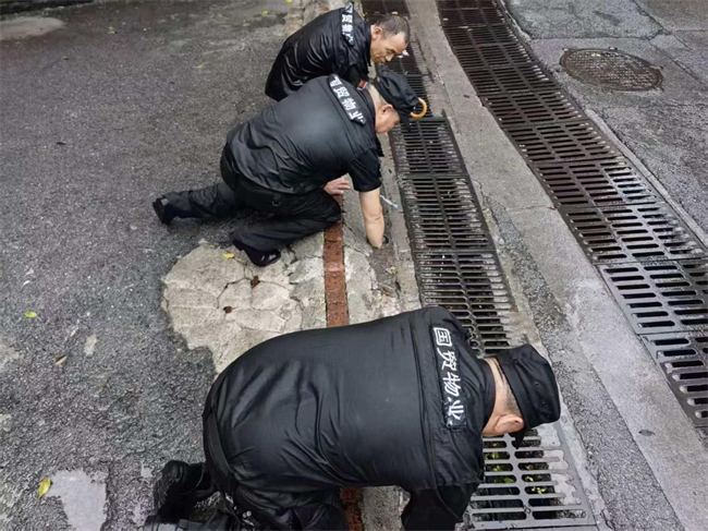 康庄美地一社区工作人员清理排水口。通讯员 凌梦琴摄